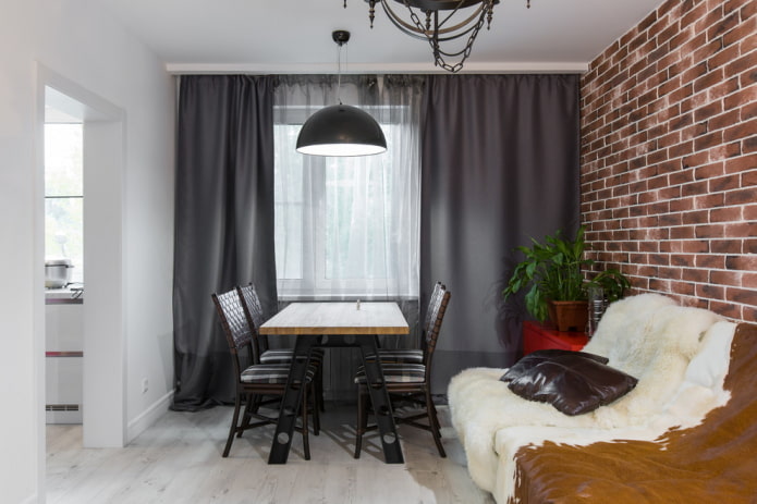 Szare zasłony, skórzana sofa i poduszki