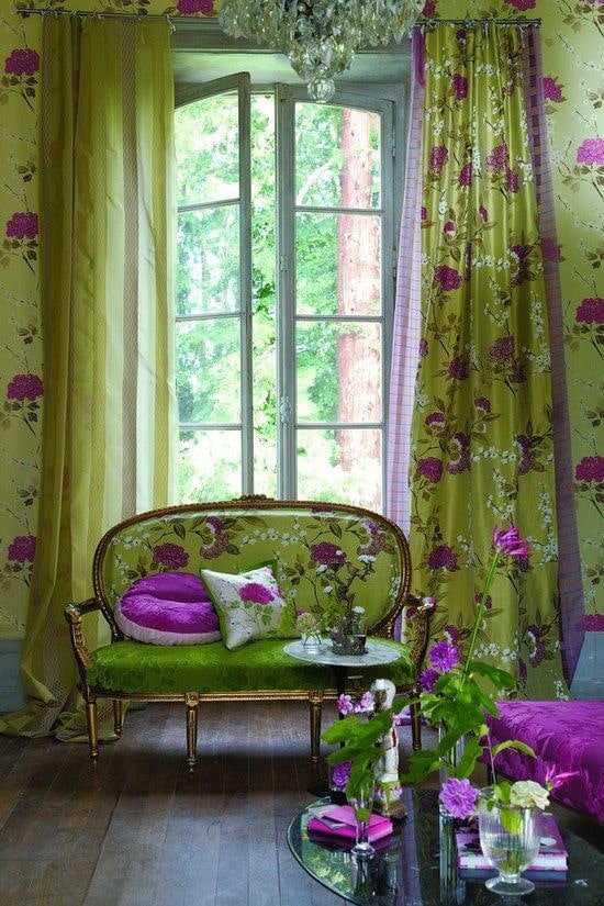 sofa z zieloną tapicerką i kwiatami we wnętrzu